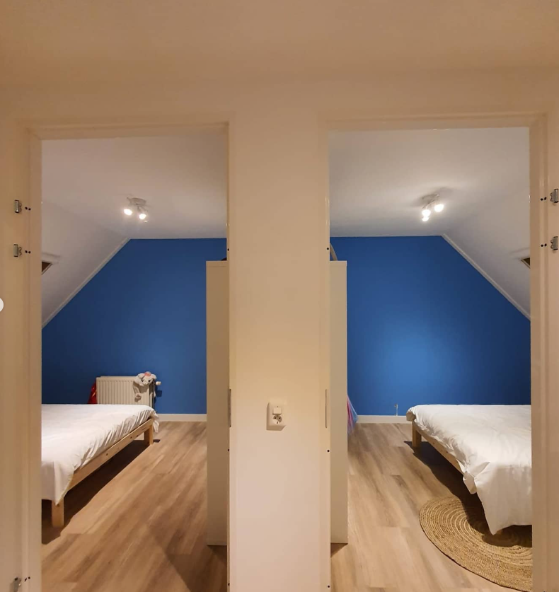 Twee afgewerkte slaapkamers op zolder met blauwe wanden