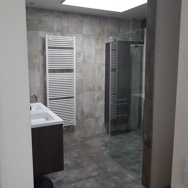 Gerenoveerde badkamer met grijze tegels