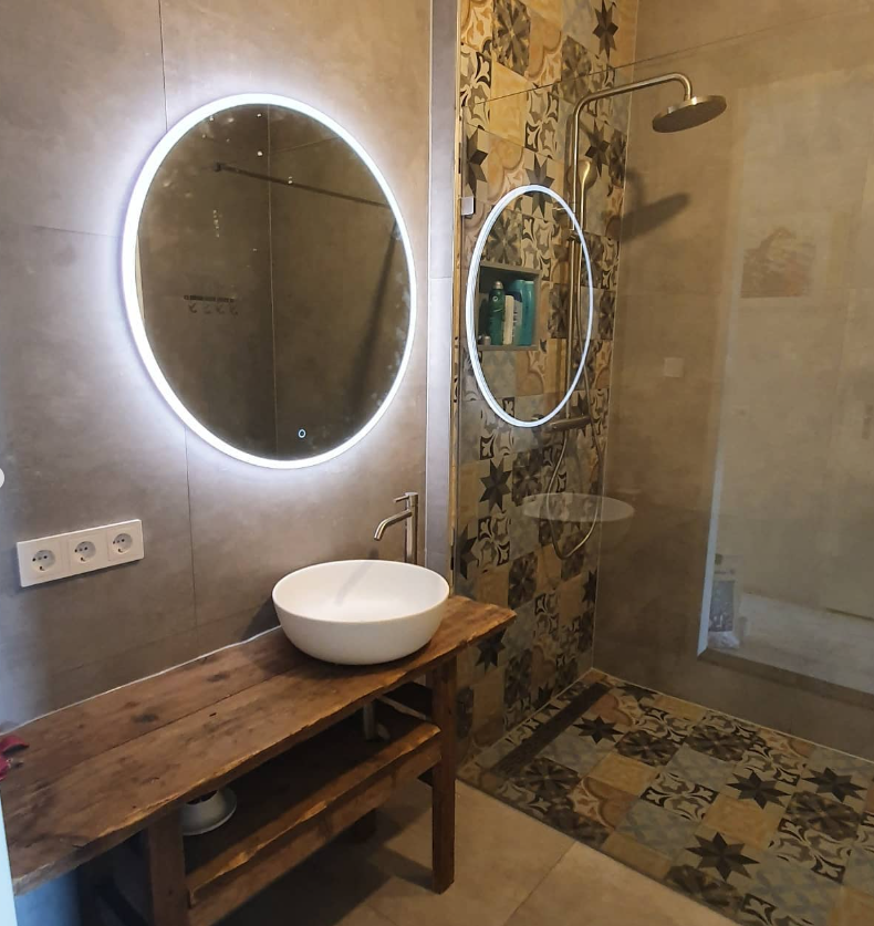Badkamer met houten wastafelblad en ronde spiegel