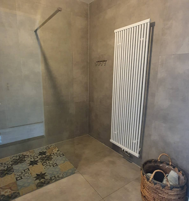 Detail van tegelvloer en radiator in de badkamer
