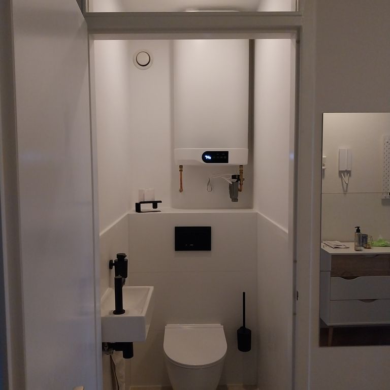 Na: hangend toilet en zwart sanitair
